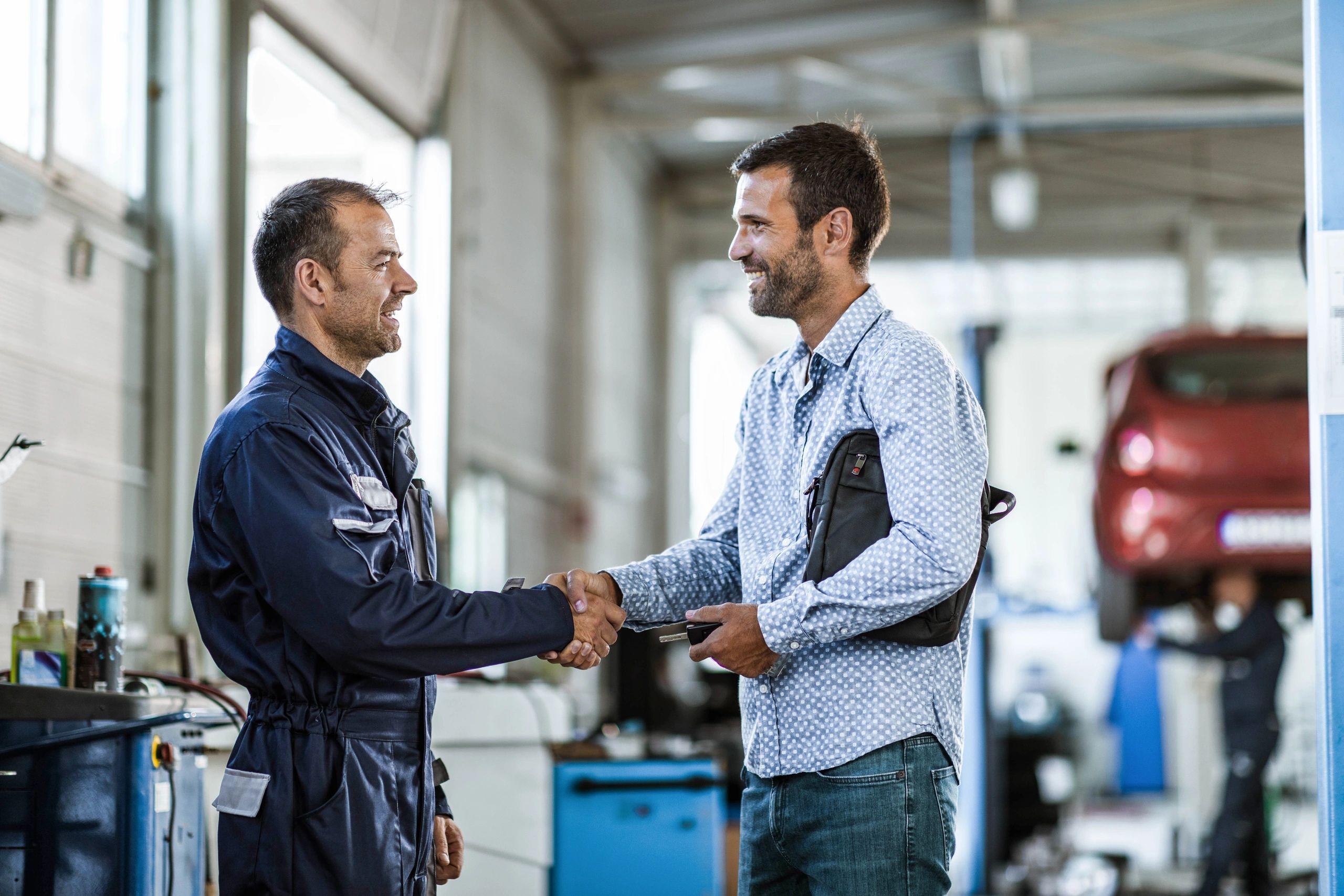 Customer shaking hands with a mechanic after service
