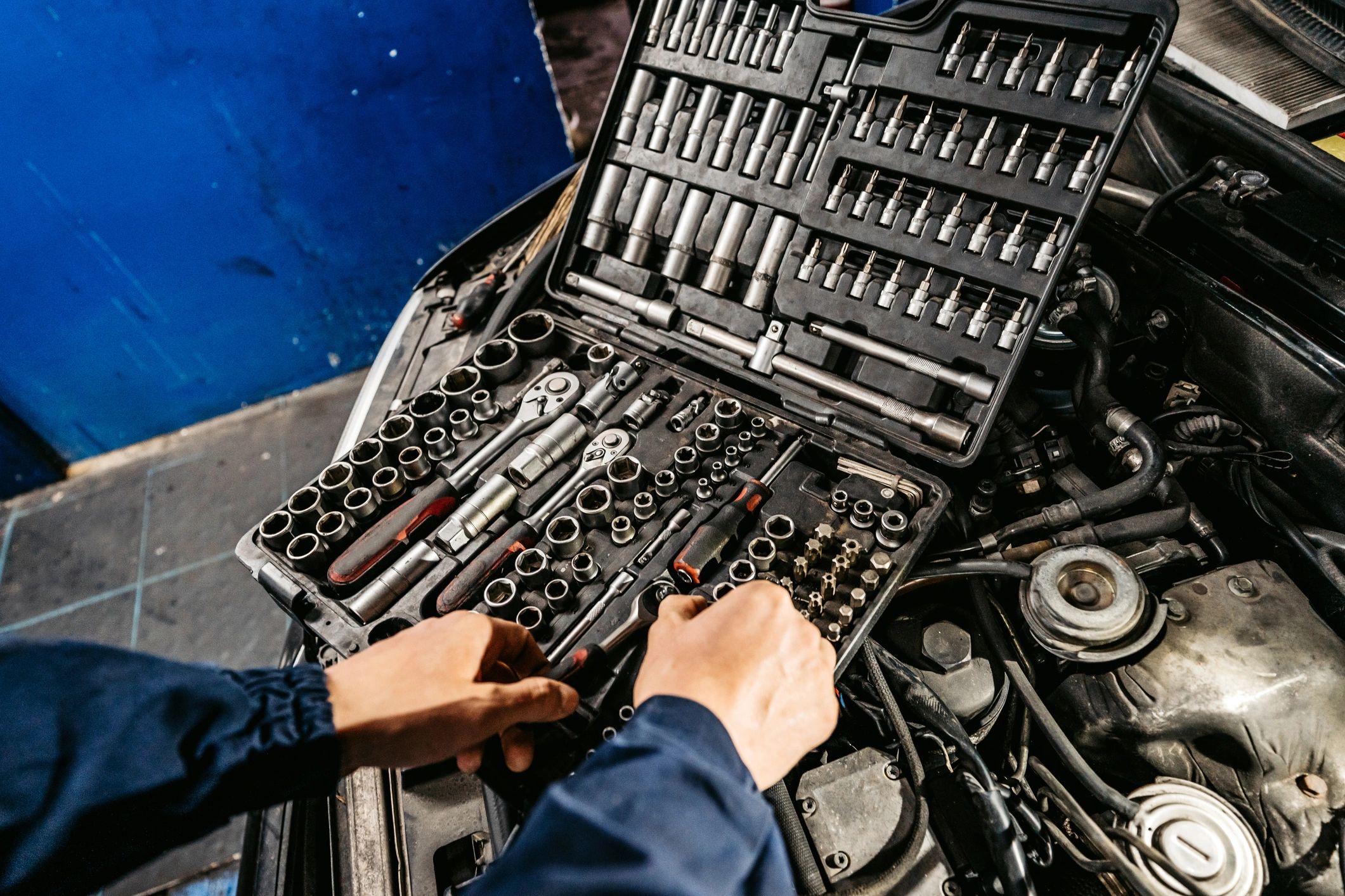 Mechanic working in an engine bay with tools