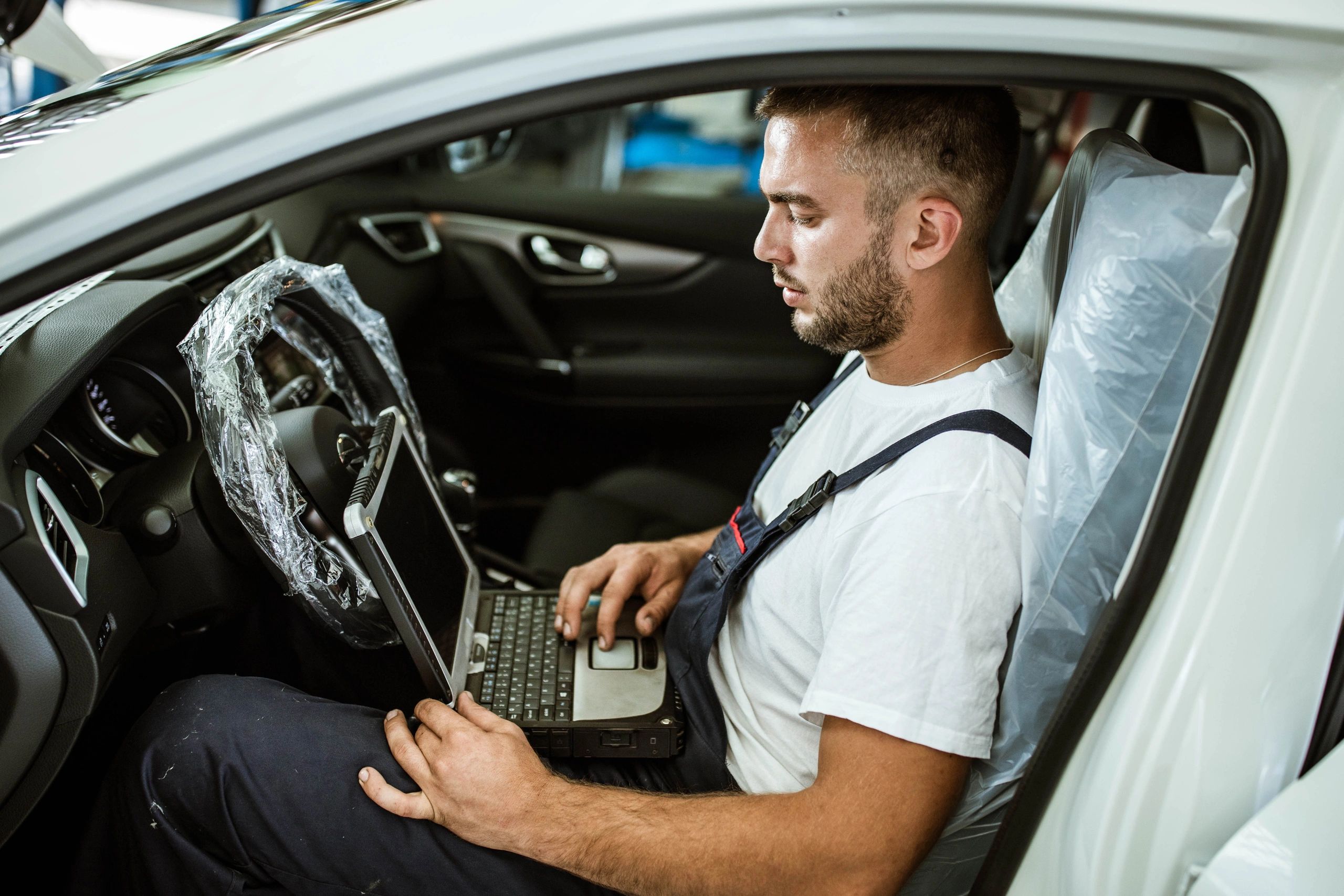 Technician working on a laptop in a workshop