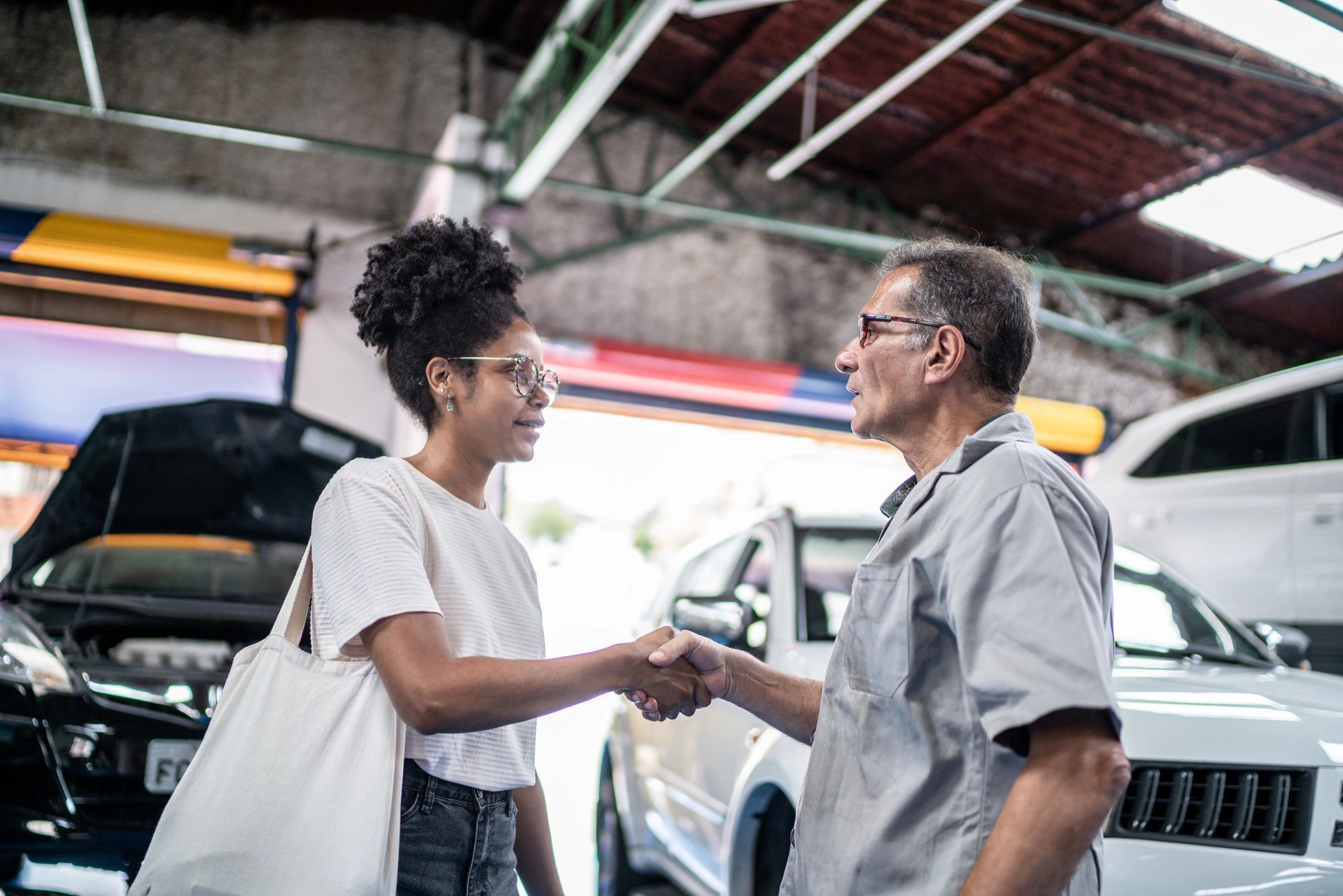 Mechanic and customer greeting each other in a repair shop