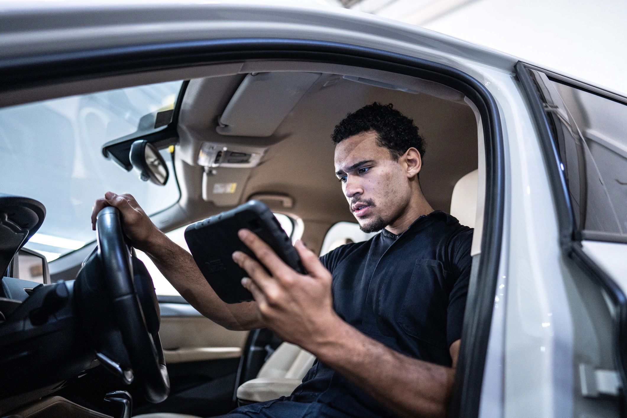 Technician using a tablet inside a vehicle during service