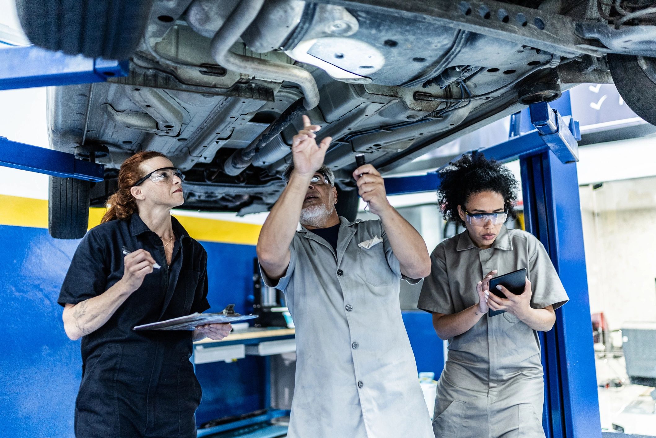 Two mechanics adjusting a vehicle in a repair shop
