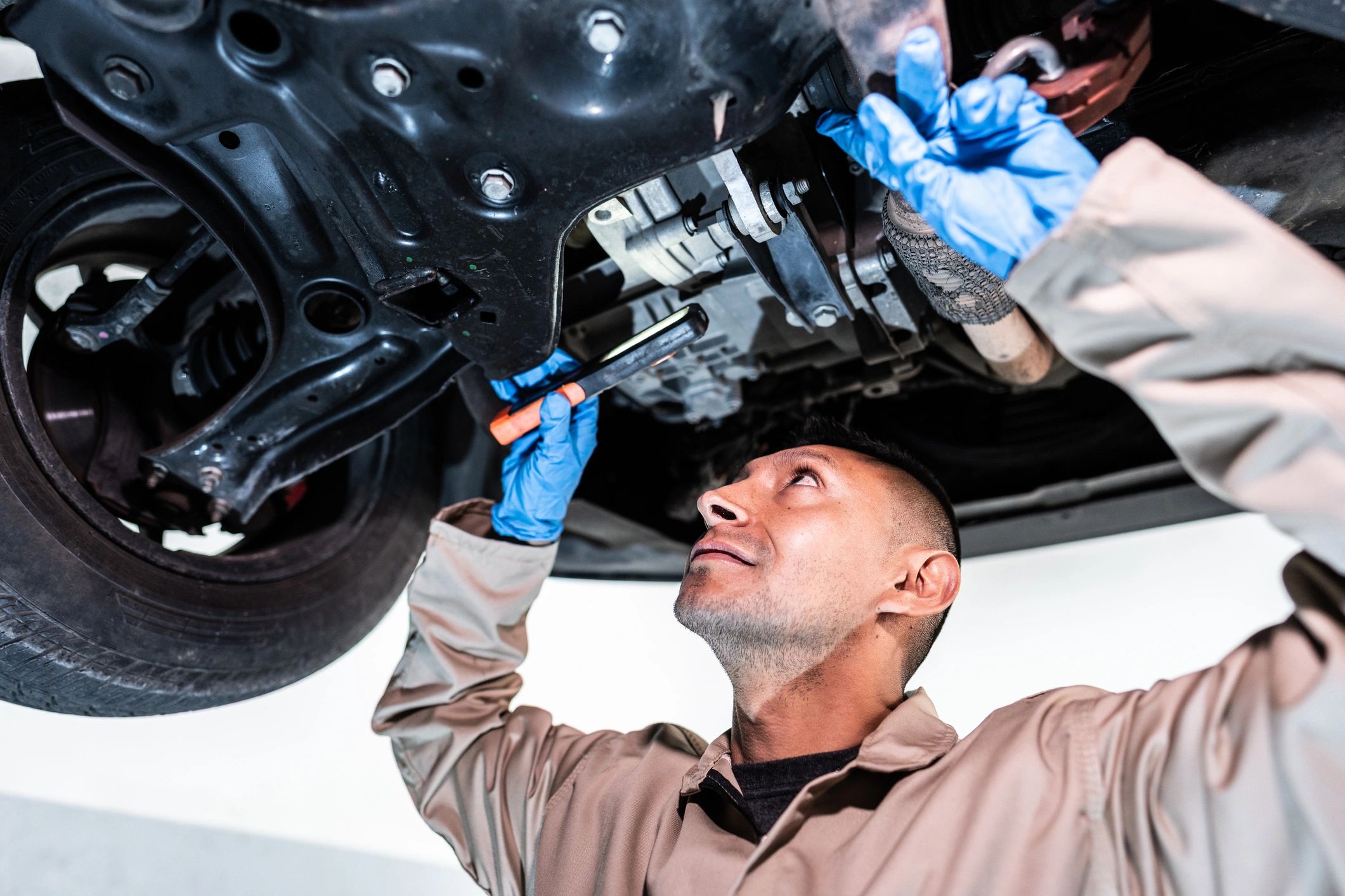 Technician working under a vehicle during transmission service