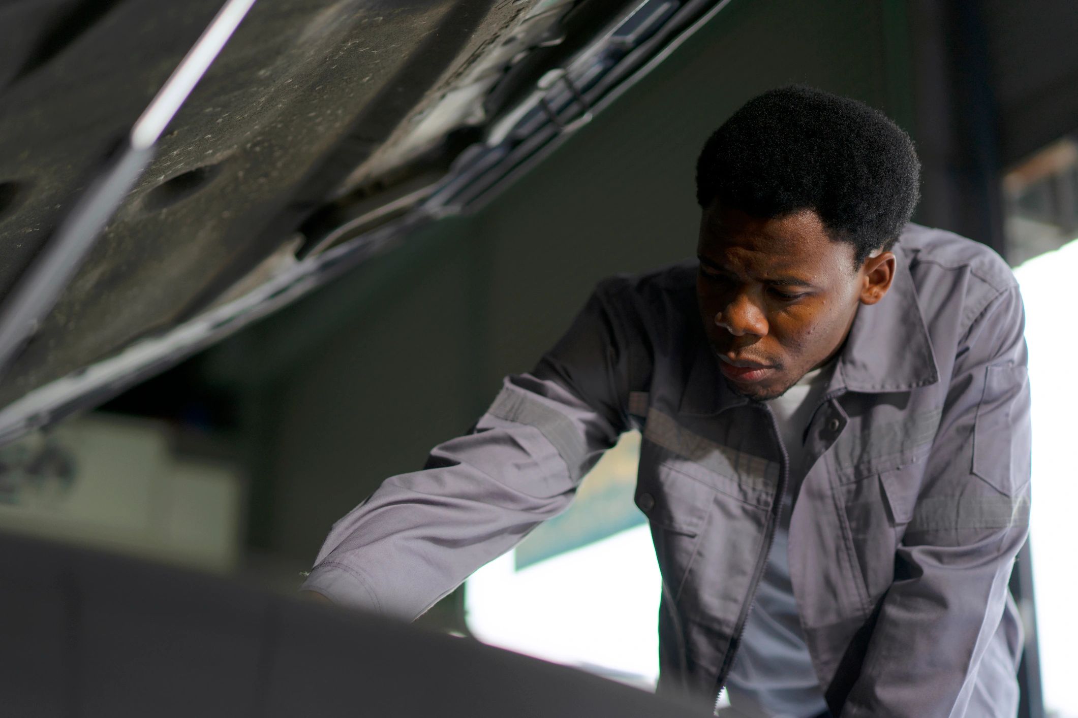 Technician working under the hood during service