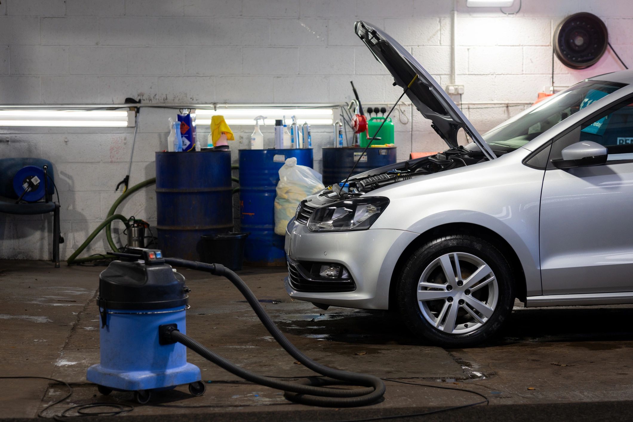 Silver car being serviced in a modern repair bay