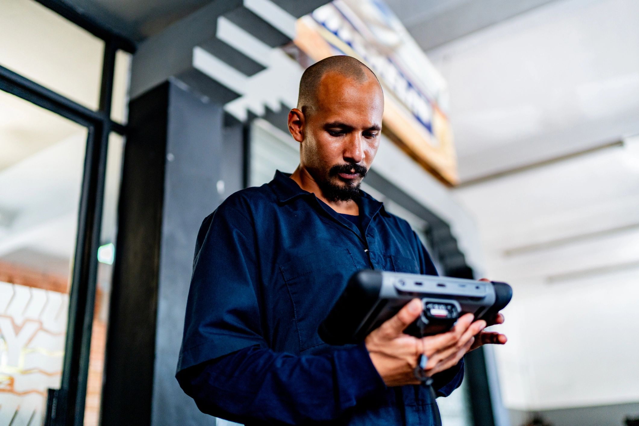 Mechanic using a diagnostic scanner on a vehicle in a repair shop