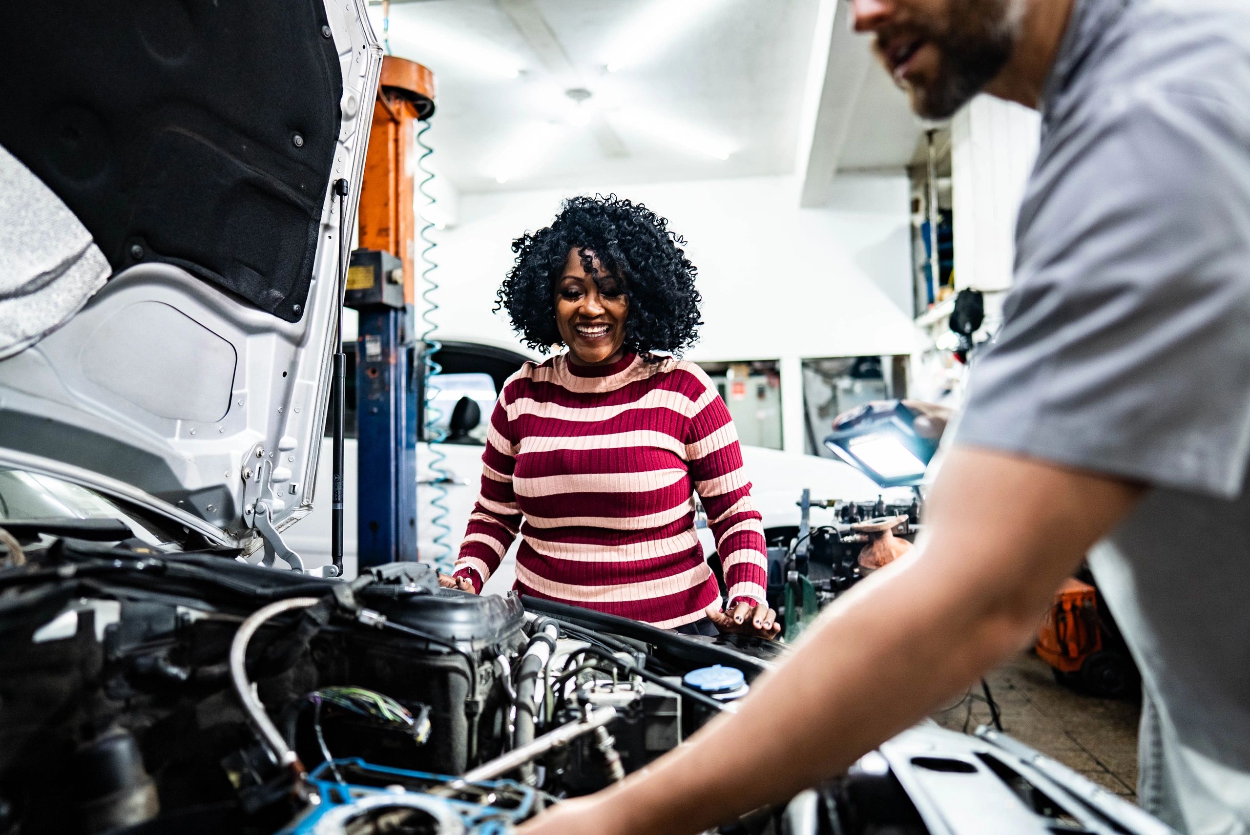 Customer speaking with an auto mechanic at a service counter
