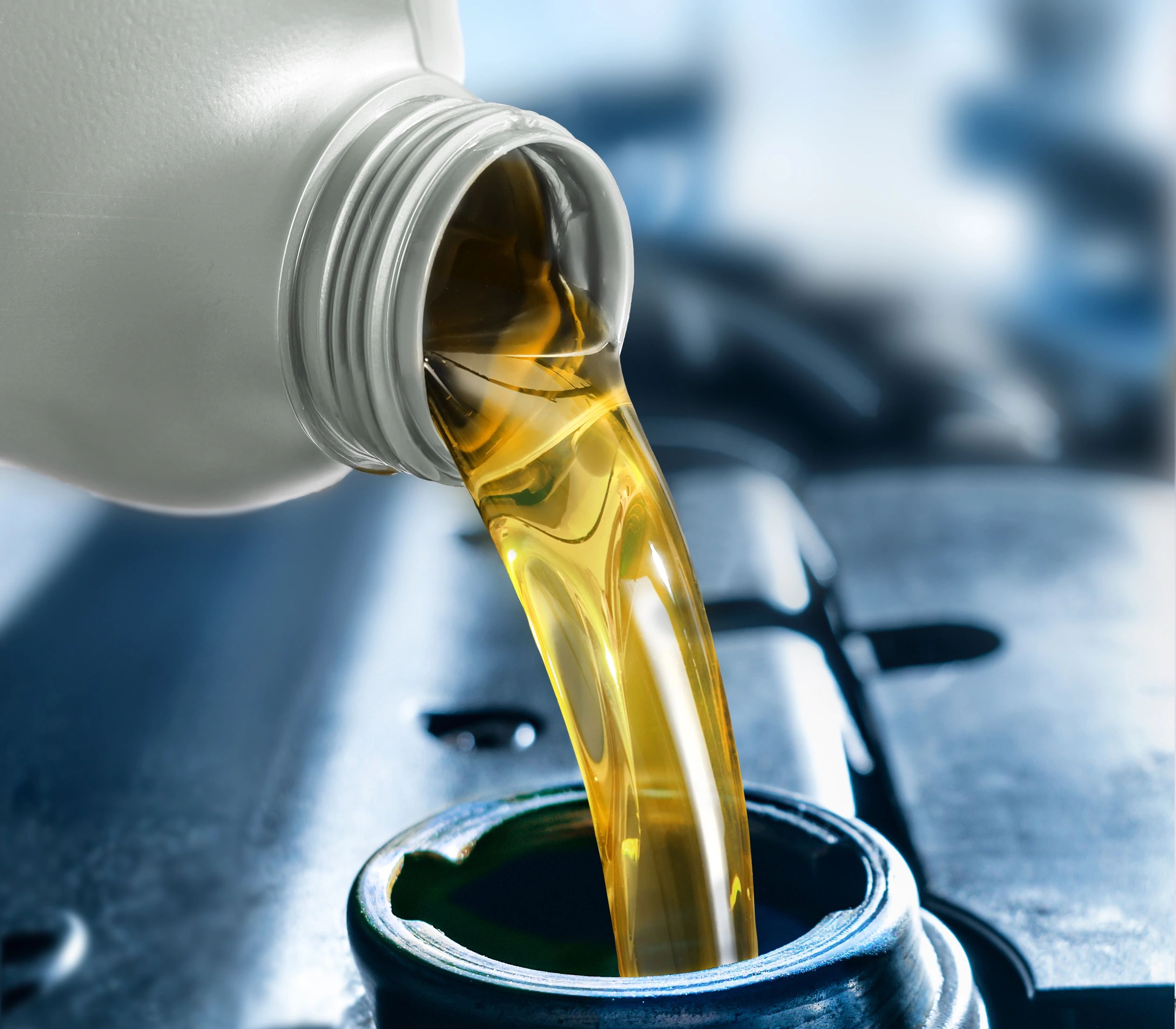 Pouring motor oil into a car engine during service