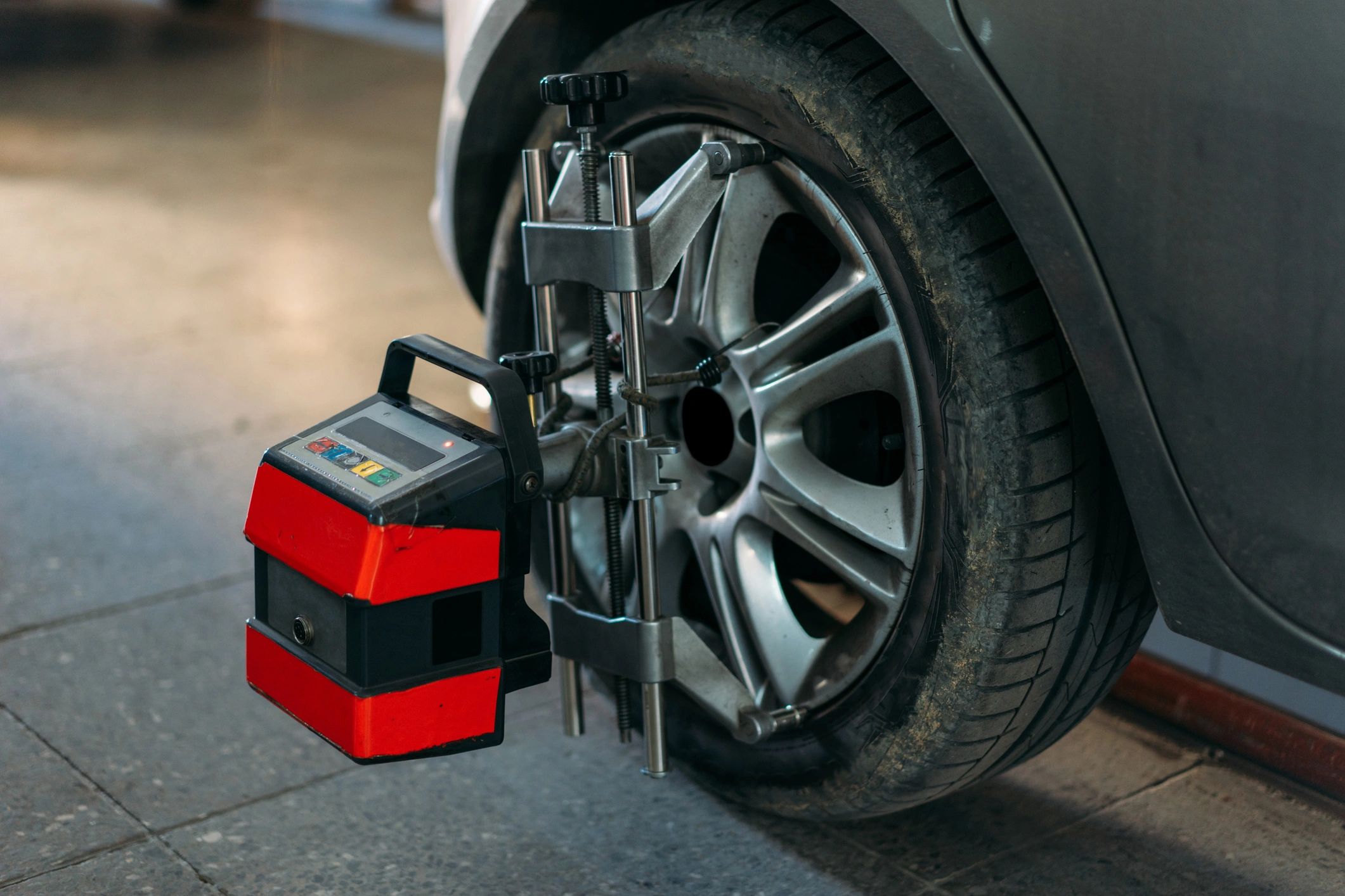 Wheel alignment equipment attached to a tire in a service bay