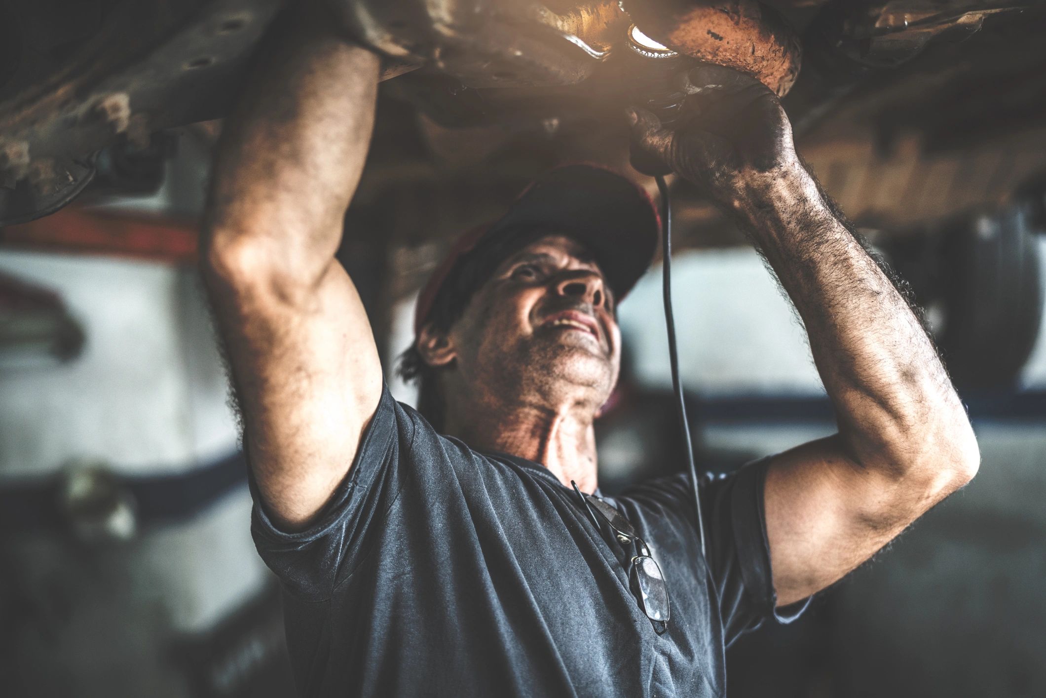 Professional mechanic working under the hood in an auto repair shop